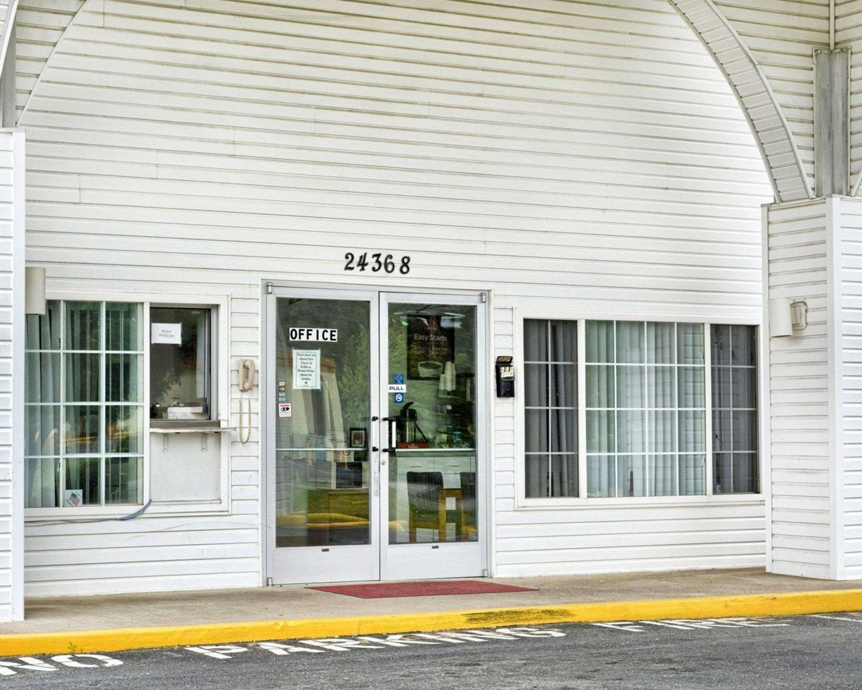 Un edificio blanco con el número 24368, una puerta de cristal con la leyenda 