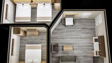 A hotel room layout with two beds, a sitting area, a kitchenette, and a bathroom.