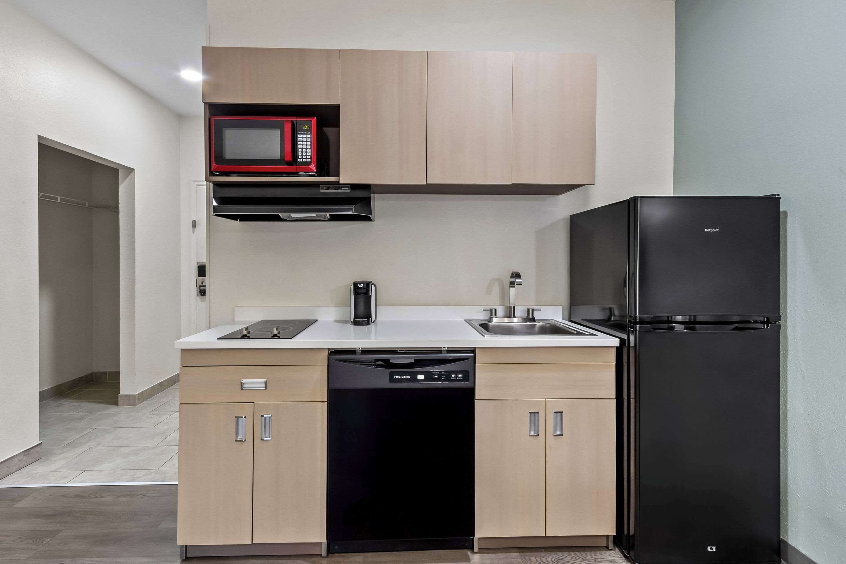 A compact kitchen with a microwave, dishwasher, and refrigerator.