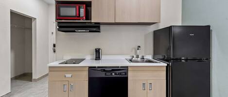 A compact kitchen with a microwave, dishwasher, and refrigerator.