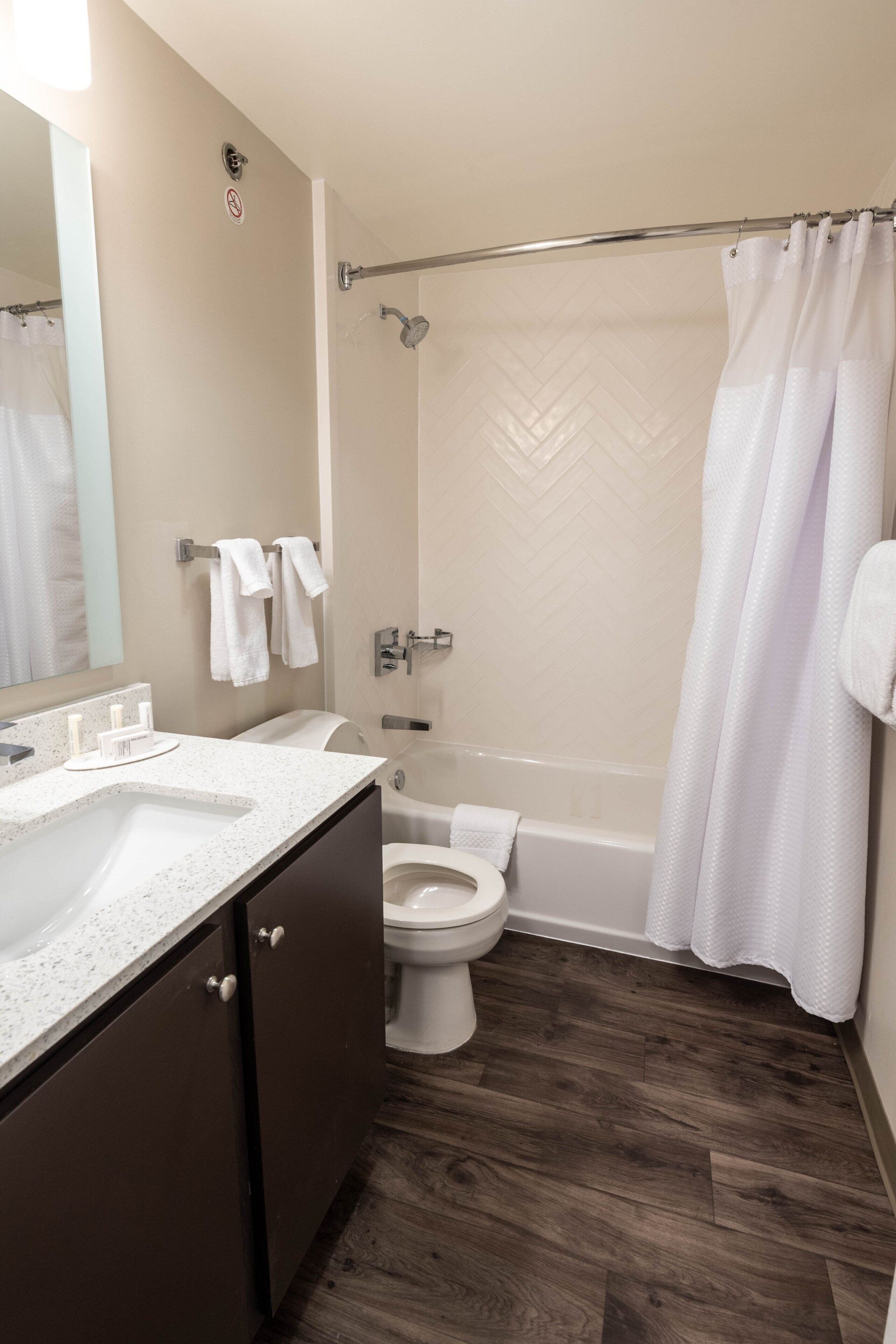 A bathroom with a shower, toilet, and sink.