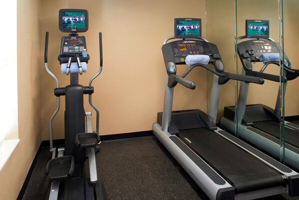 A gym with treadmills and an elliptical machine, equipped with digital screens and control panels. - Sonesta Simply Suites Detroit Novi (Novi)