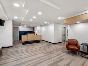 A modern interior with a reception desk, a seating area, and a kitchenette. - Sonesta Simply Suites Detroit Novi (Novi)