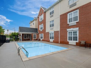 A residential building with a swimming pool, a covered patio, and a fenced entrance. - Sonesta Simply Suites Detroit Novi (Novi)