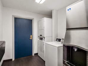 A compact kitchen with a blue door, stacked appliances, and a built-in oven. - Sonesta Simply Suites Detroit Novi (Novi)