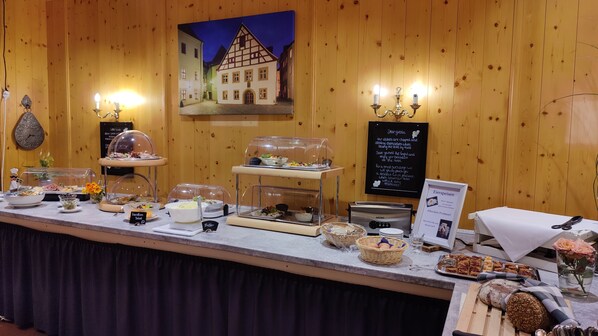 A buffet setup with various food items and a signboard with text.