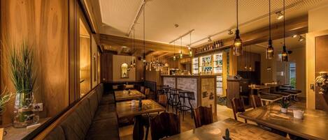 A restaurant interior with wooden paneling, a bar area, and seating arrangements.