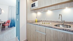Une cuisine moderne dotée d’un plan de travail en granit, d’un évier en acier inoxydable et de meubles en bois.