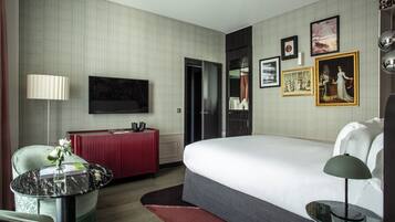 A hotel room with a bed, a TV, a desk, and a chair.