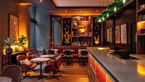 A bar area with seating, bookshelves, and a wooden ceiling. - Hotel Indigo Paris - Opera by IHG (Paris)