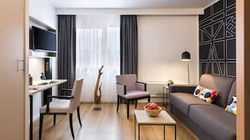 Un salon moderne avec un canapé, une table à manger et un téléviseur.