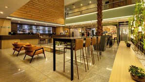 Un moderno vestíbulo de hotel con mostrador de recepción, área de estar y una larga barra.