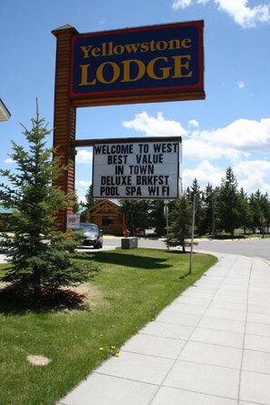 Placa para o Yellowstone Lodge com mensagem de boas-vindas e lista de comodidades.