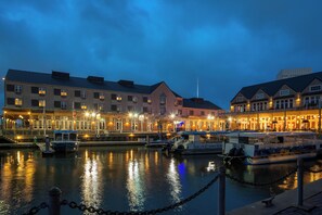 A waterfront hotel with multiple buildings, a dock with boats, and a chain barrier. - Harbor House Hotel and Marina at Pier 21 (Galveston)