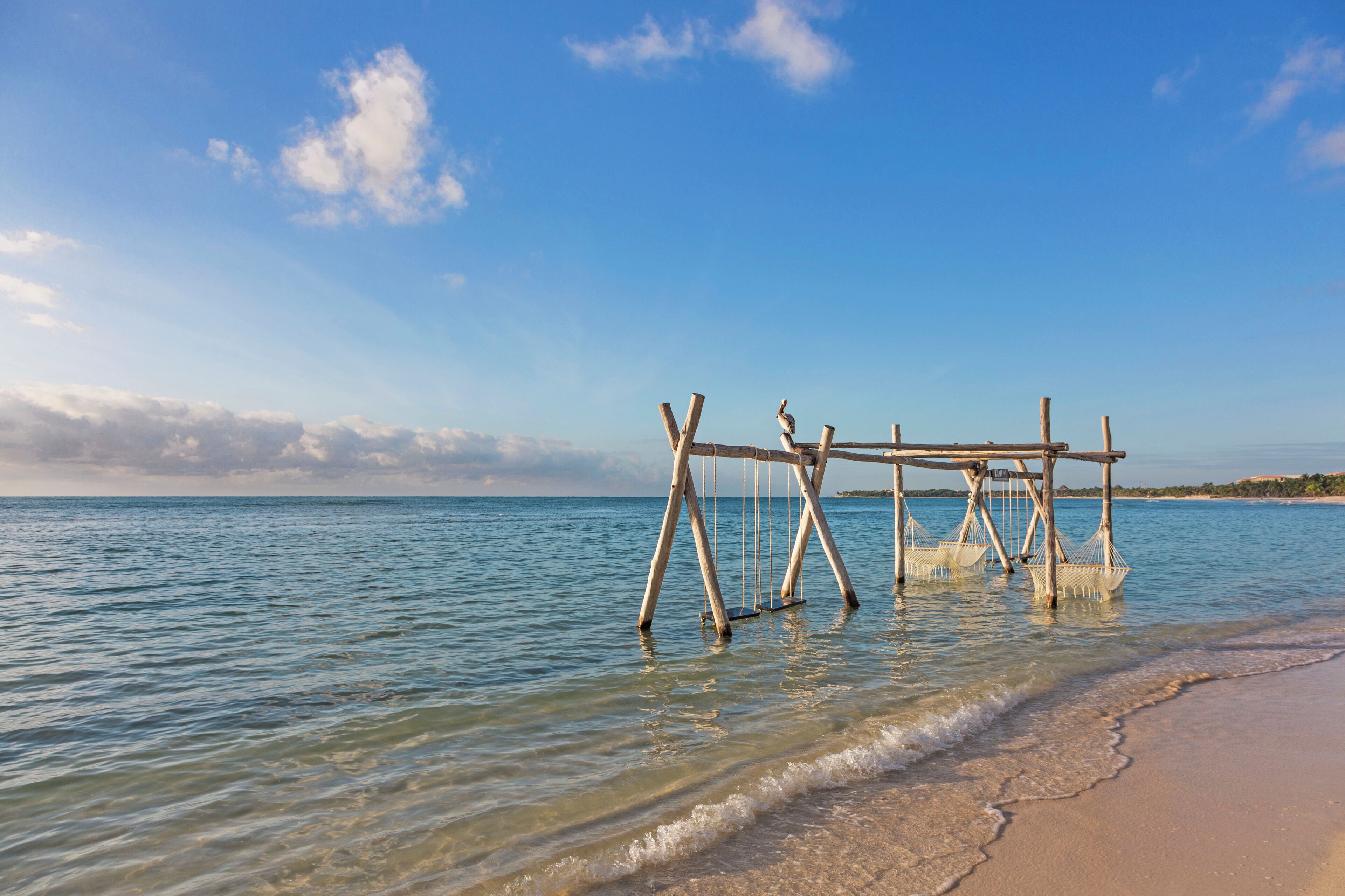 Une structure en bois qui s’avance dans l’eau, près d’une plage.