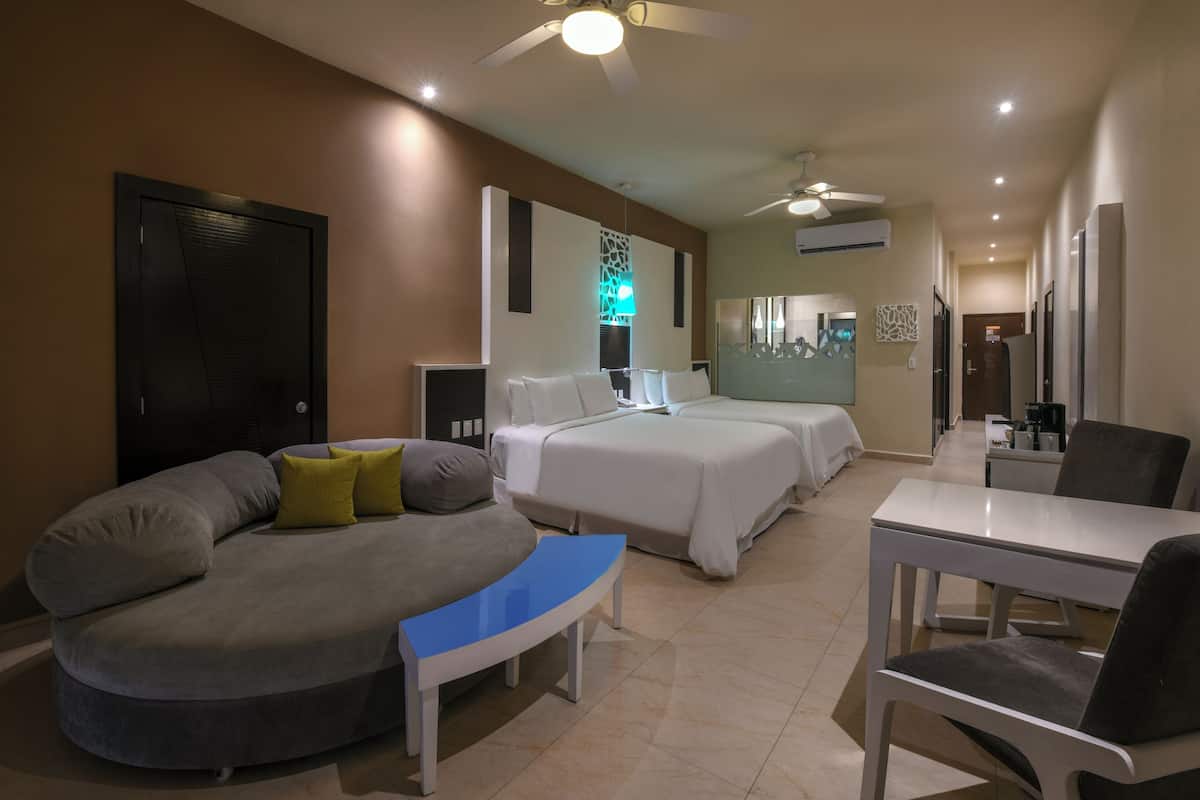 Una habitación de hotel moderna con un sofá curvo, una cama, un escritorio y una silla.