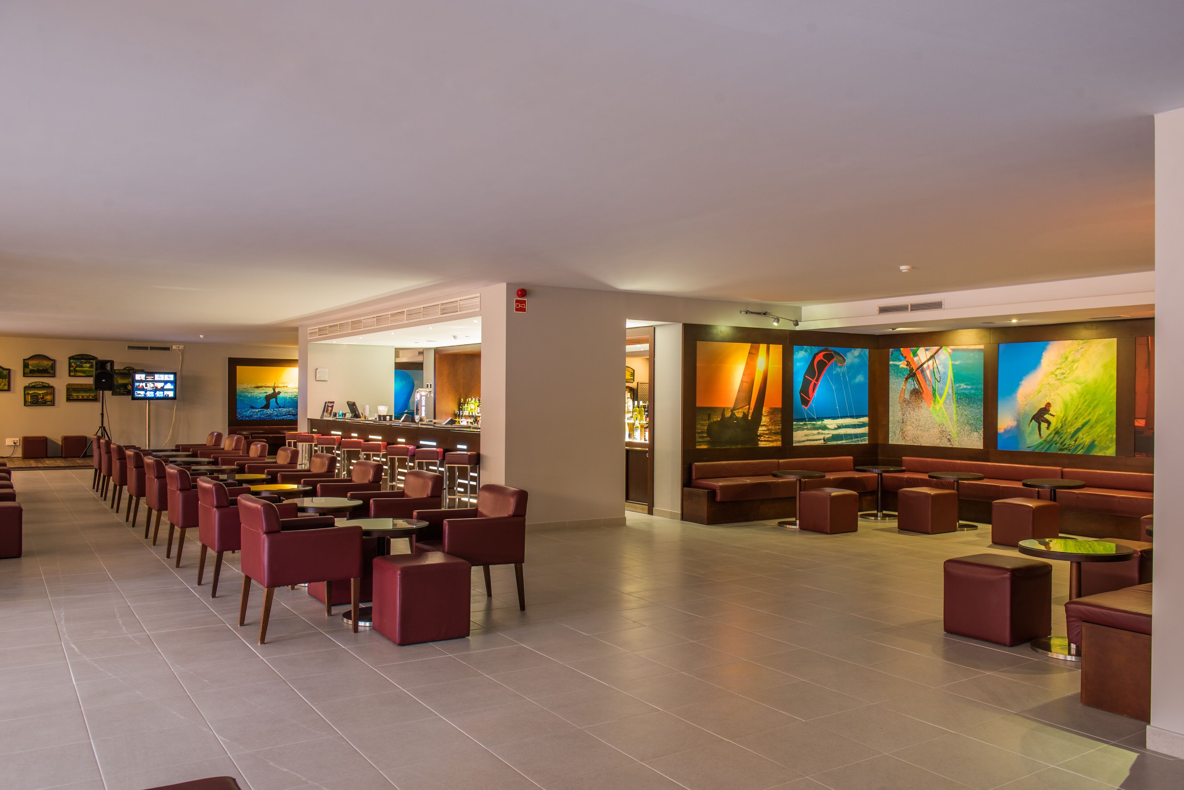 Un hall d’entrée spacieux avec de nombreux sièges, un bar et de grandes œuvres d’art mural.