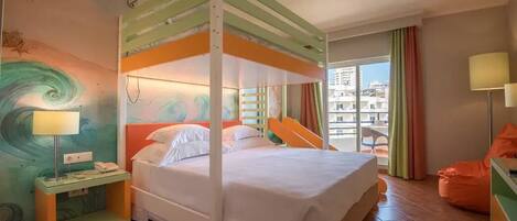 A room with a bunk bed, a bedside table with a lamp, a chair, and a view of the city through large windows.