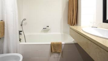 Une salle de bain avec une baignoire, un lavabo et un miroir.