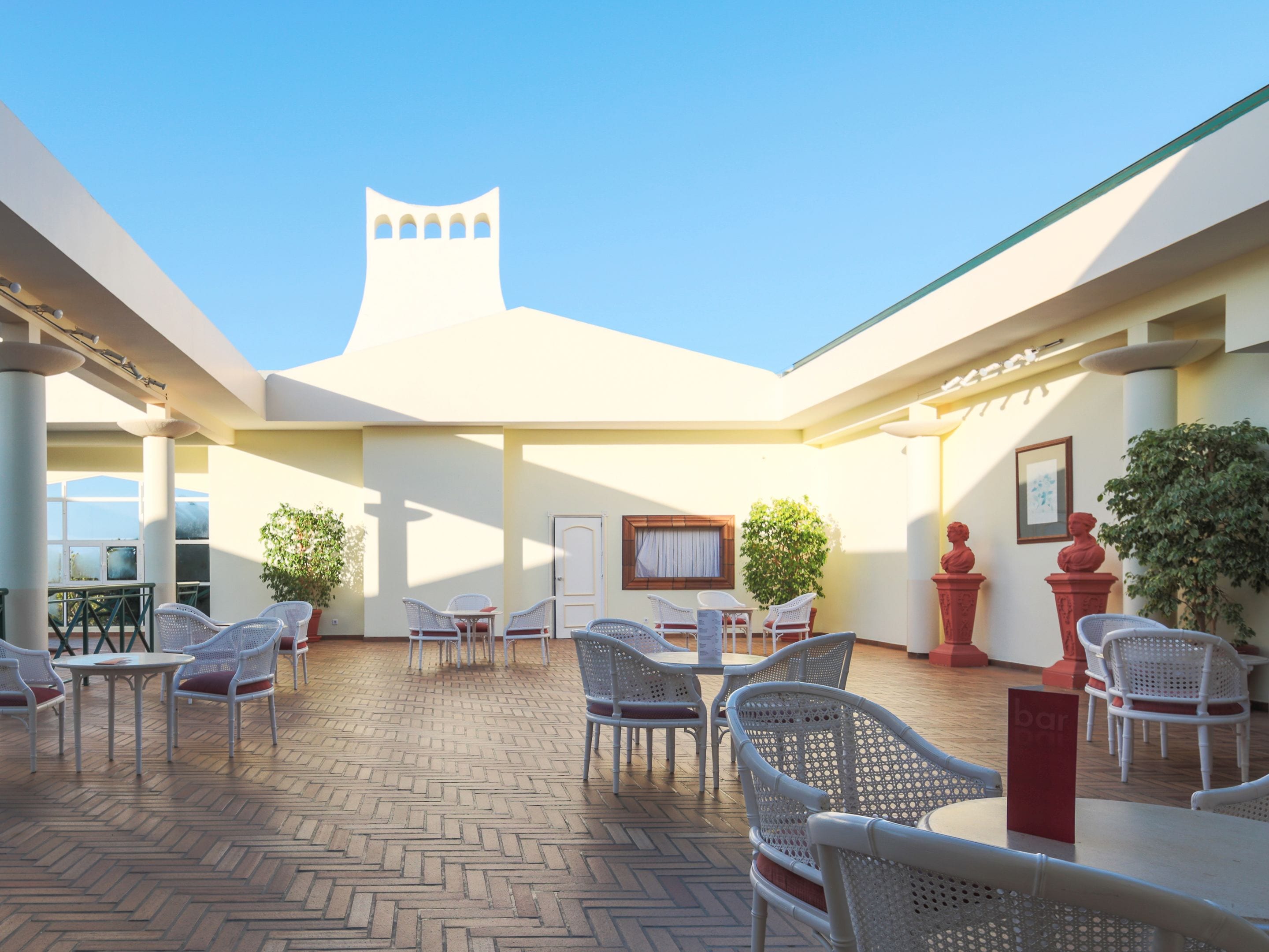 A courtyard with outdoor seating, a central fountain, and a distinctive tower-like structure.