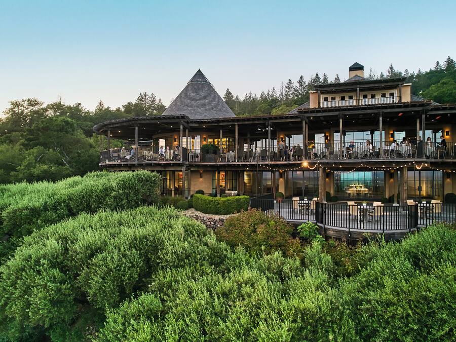 A multi-story building with outdoor seating areas and a dining room.