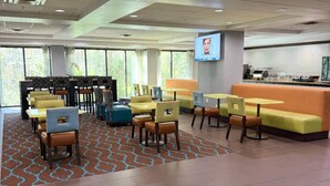 A hotel lobby with a seating area, a reception desk, and a television screen. - Comfort Inn & Suites Tampa North I-75 (Tampa)