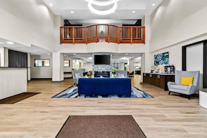 A spacious living area with a high ceiling, a central fireplace, and a dining area with a blue tablecloth.