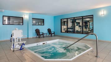 Un área de piscina con jacuzzi, sillas y equipo de ejercicios.