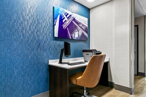 A modern office space with a desk, chair, computer, and printer.