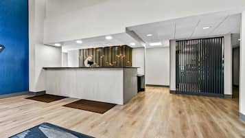 A modern reception area with a wooden reception desk, recessed lighting, and a blue accent wall.