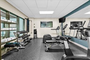 A gym with exercise equipment, a treadmill, and a weight rack. - Comfort Inn & Suites Grand Blanc/Flint (Grand Blanc)