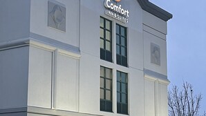 A Comfort Inn & Suites building with a modern design, featuring a prominent logo on the facade. - Comfort Inn & Suites Grand Blanc/Flint (Grand Blanc)