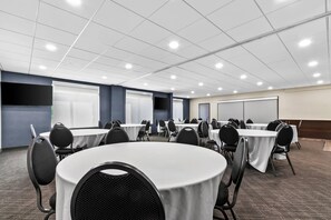 A conference room with round tables, chairs, and a whiteboard. - Comfort Inn & Suites Grand Blanc/Flint (Grand Blanc)