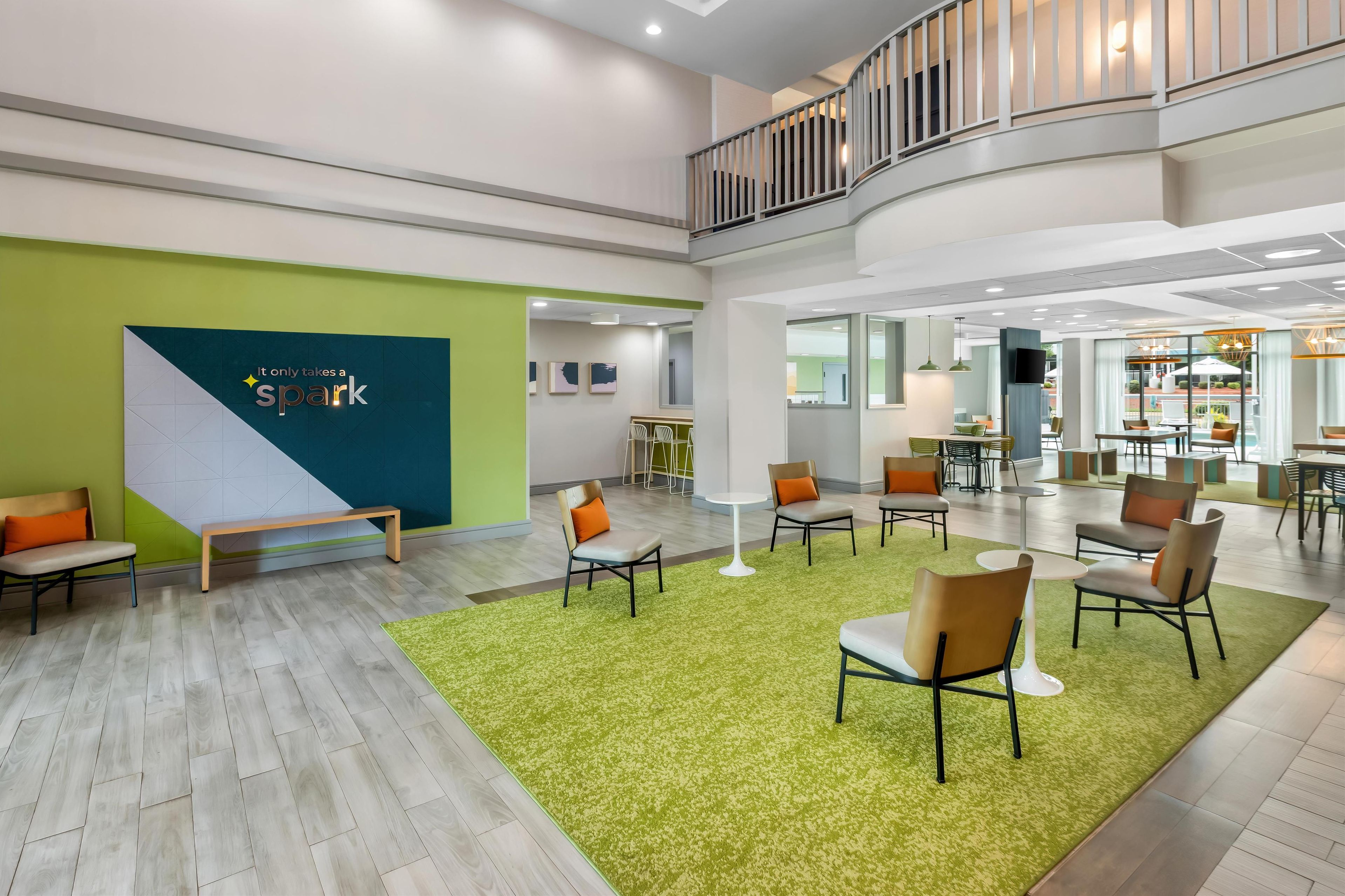 A spacious lobby with a green wall, seating area, and a staircase.