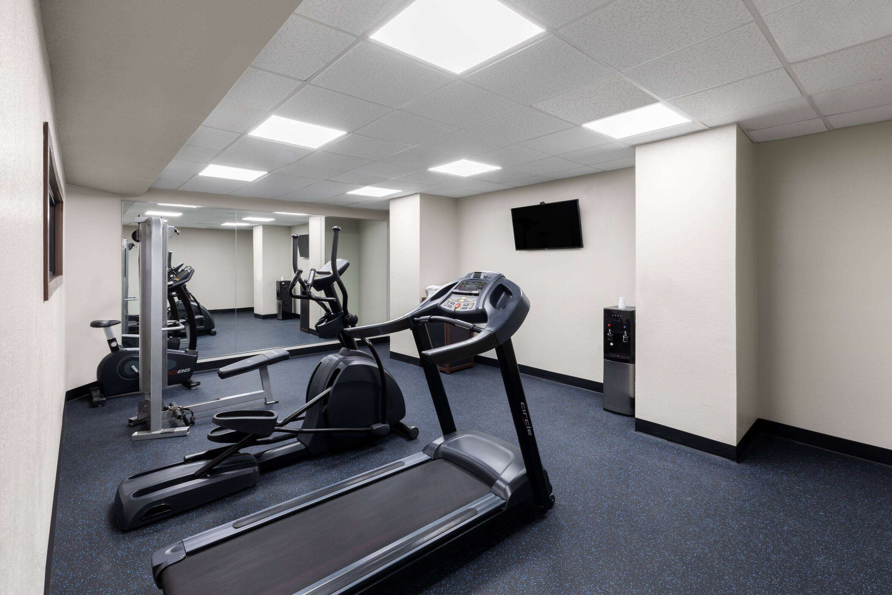 A gym with treadmills, elliptical machines, and weight equipment.