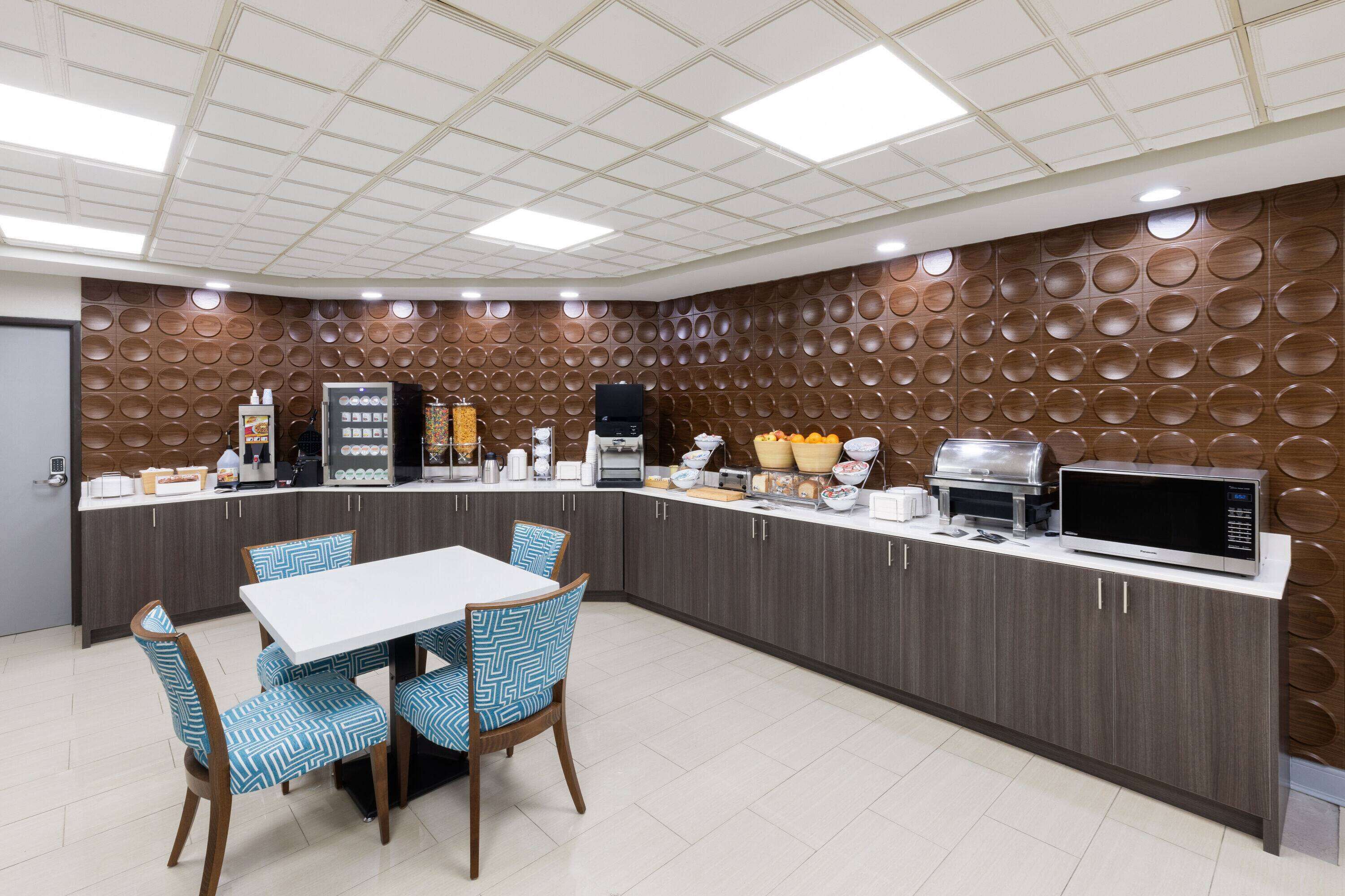 A modern kitchen with a central island, a microwave, and various appliances.