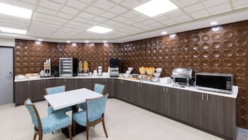 A modern kitchen with a central island, a microwave, and various appliances.