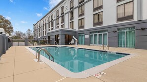 Ein modernes Hotel mit Schwimmbad, Außenbereich und einer großzügigen Fassade.