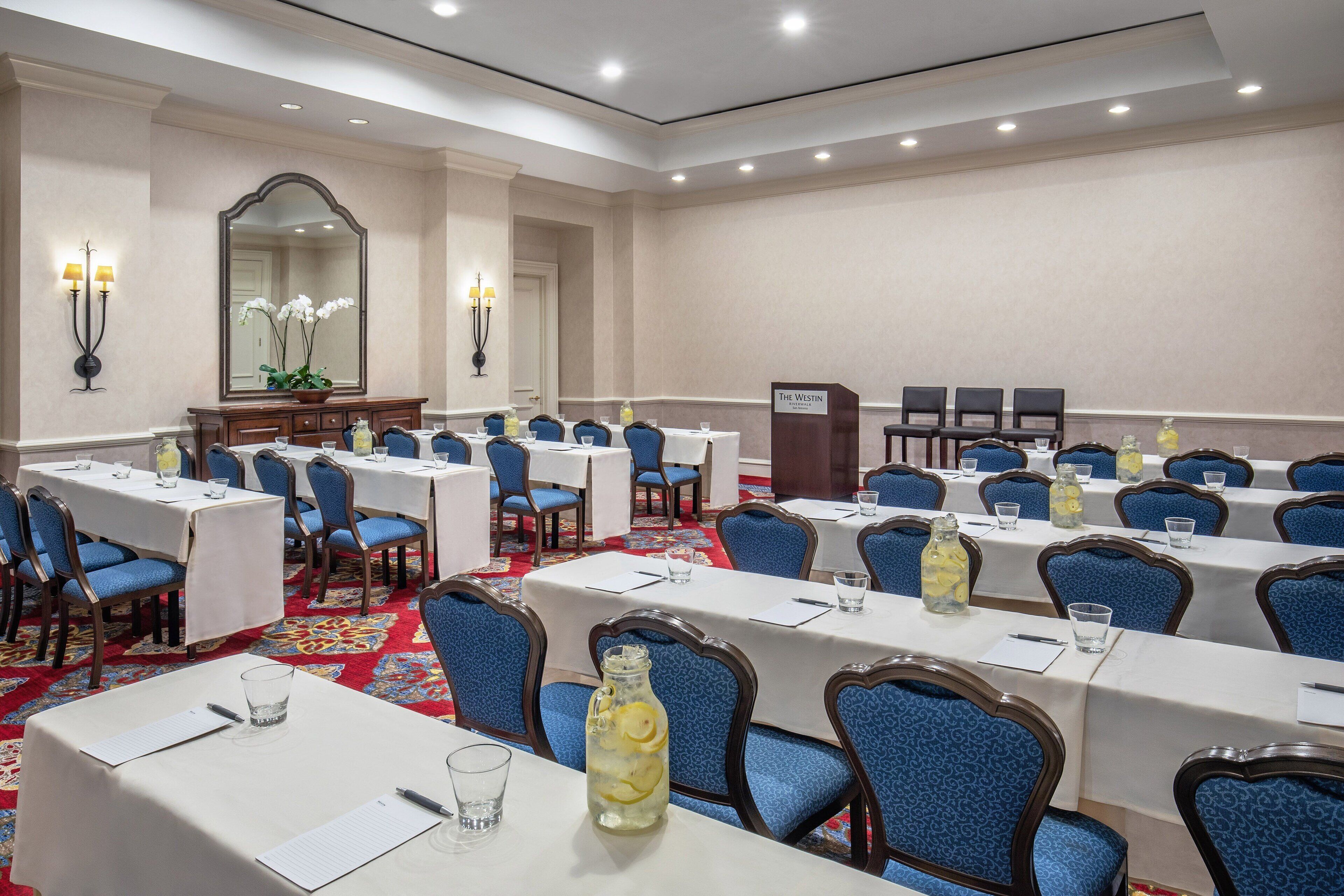 Une salle de conférence équipée de tables, de chaises et d’un pupitre portant l’inscription « The Westin ».