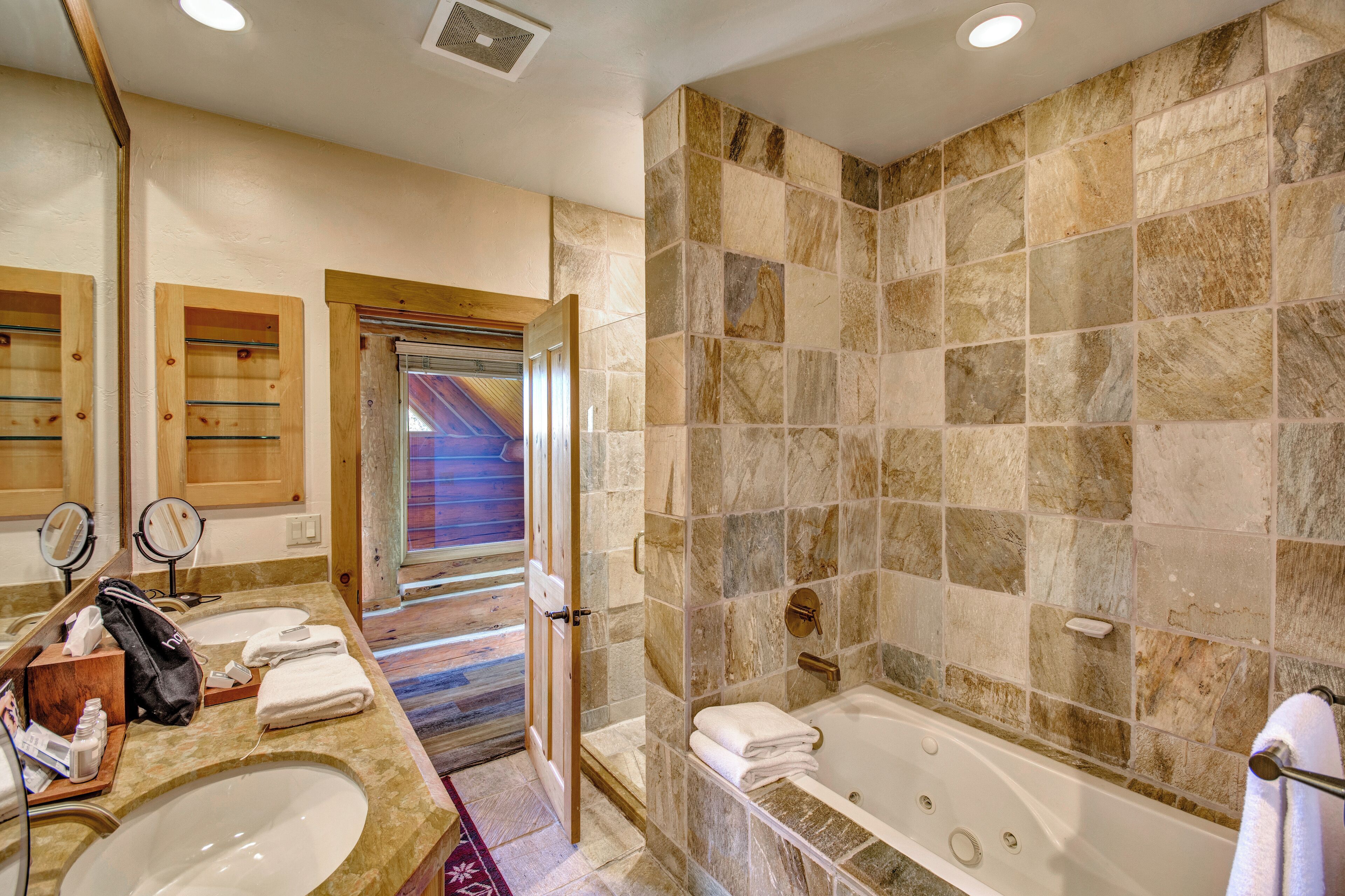 A bathroom with two sinks, a bathtub, and a shower.
