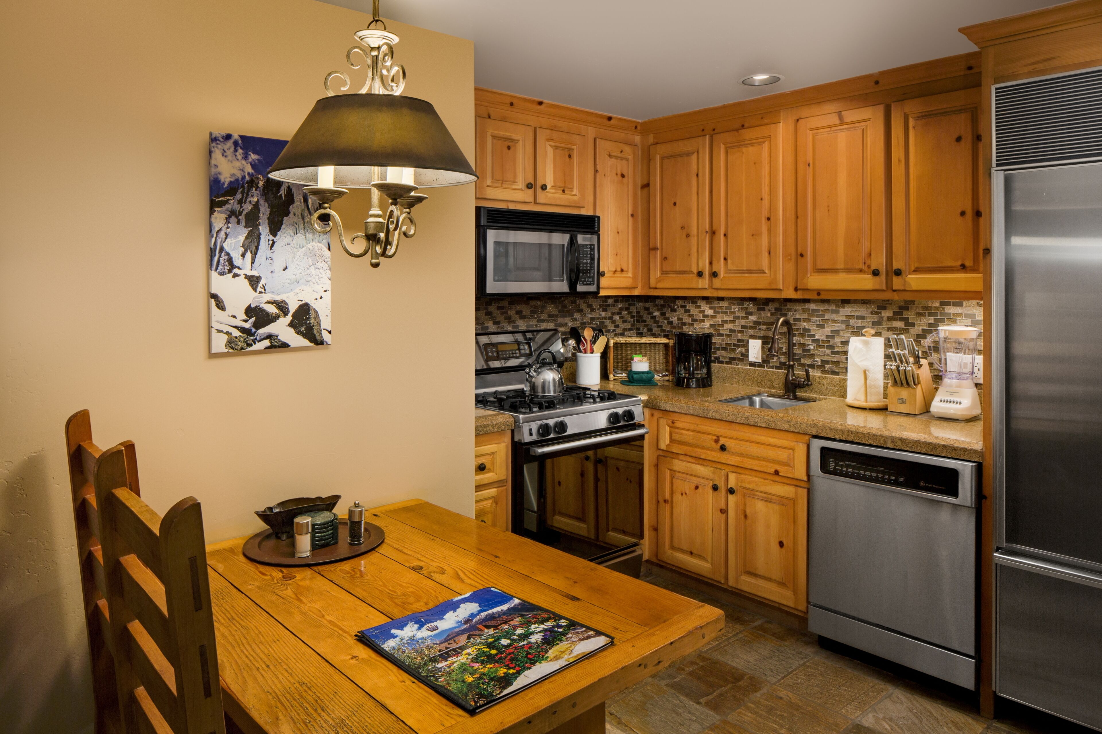 A kitchen with wooden cabinets, a stainless steel refrigerator, a microwave, a stove, and a dishwasher.
