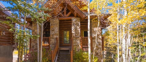 A log cabin with a stone foundation, wooden beams, and a wooden staircase leading to a door labeled "Humboldt."