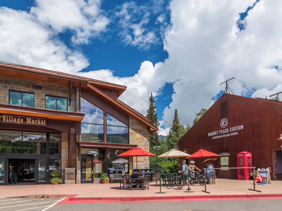 A building with a storefront labeled "Village Market" and a sign for "Market Plaza Station."
