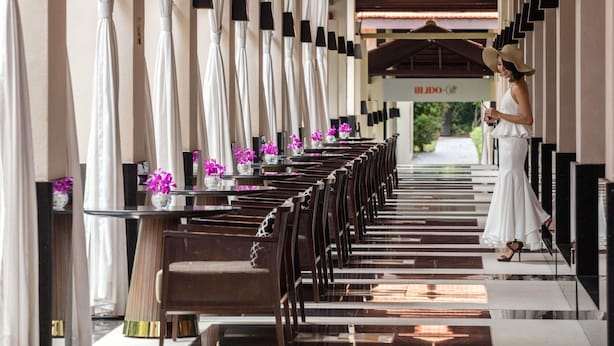 A hotel corridor with rows of seating, a ceiling fan, and a sign for 'ILDO'. - Sofitel Singapore Sentosa (Singapore)