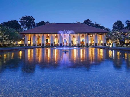 A hotel with a pool, a fountain, and a covered area with lights.. Sofitel Singapore Sentosa