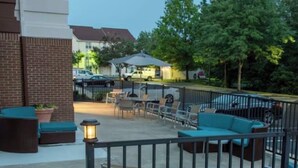 An outdoor patio area with seating, a lamp post, and a fenced area.