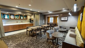 A hotel lobby with a coffee bar, seating area, and a sign for Springhill Suites.