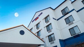 Ein Hotel mit modernem Design, das mehrere Fenster aufweist und eine Schilder mit dem Aufschrift 'Springhill Suites' hat.
