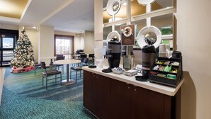 Eine Hotelhalle mit Kaffee-Ecke, einem Weihnachtsbaum und einer Sitzecke.