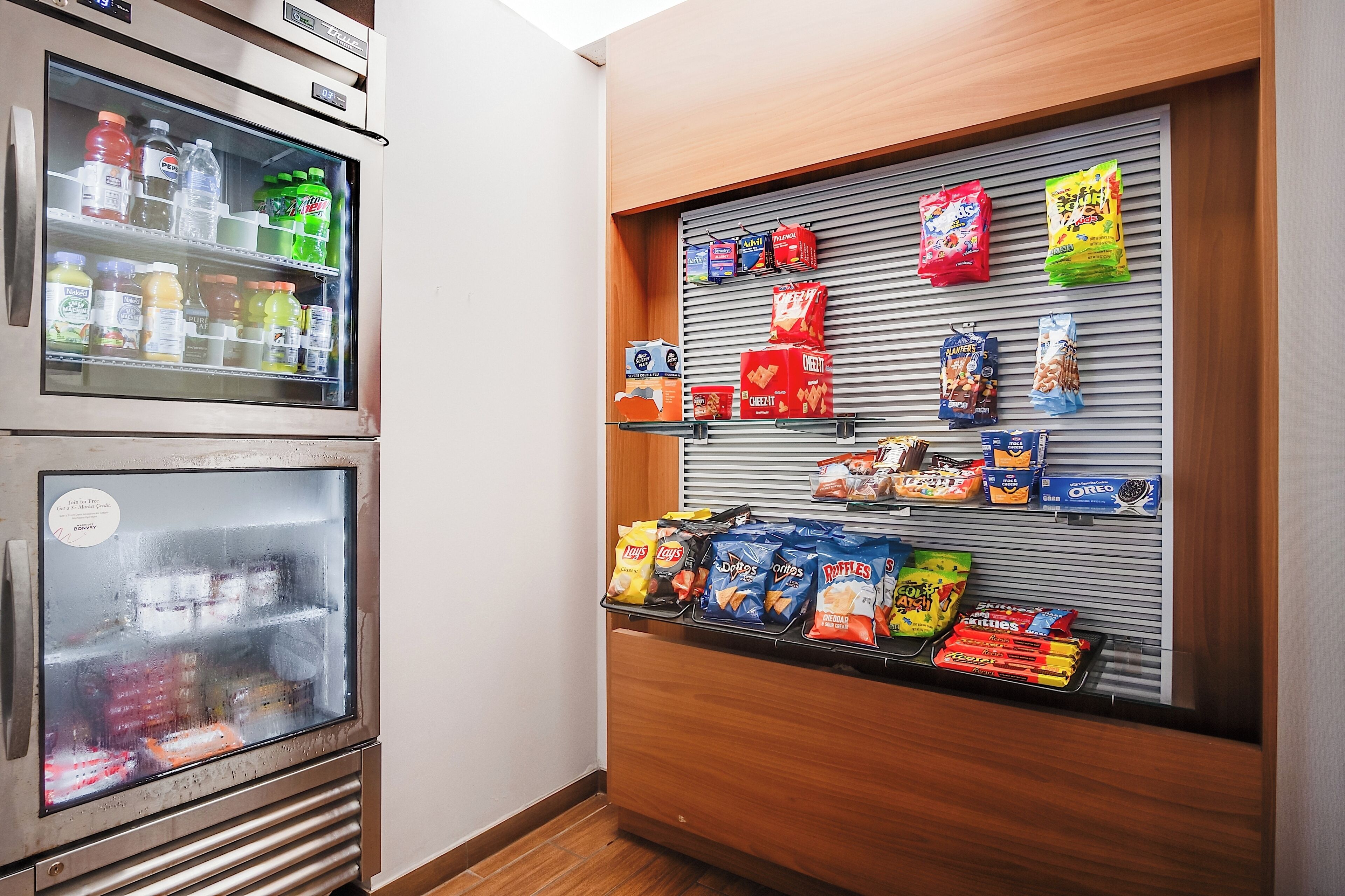 Un distributeur automatique proposant une variété de boissons et d’en-cas, notamment des sodas, de l’eau et des chips.
